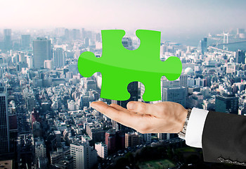 Image showing close up of man holding green puzzle piece