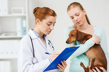 Image showing woman with dog and doctor at vet clinic