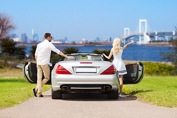 Image showing happy man and woman near cabriolet car in tokyo