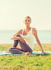 Image showing young woman making yoga exercises outdoors