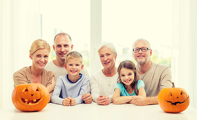 Image showing happy family sitting with pumpkins at home