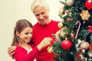 Image showing smiling family decorating christmas tree at home