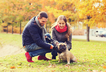 Image showing smiling couple with dog in autumn park