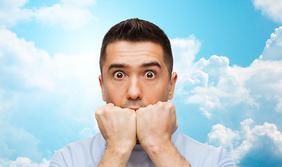 Image showing scared man over blue sky and clouds background