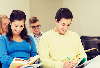 Image showing group of smiling students with notebooks