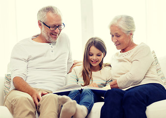 Image showing smiling family with book at home