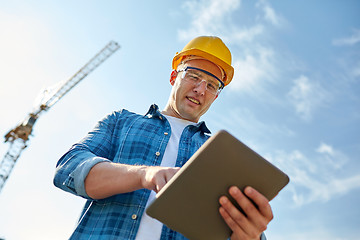 Image showing builder in hardhat with tablet pc at construction