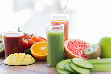 Image showing close up of fresh juice glass and fruits on table