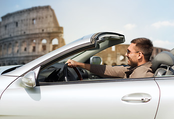 Image showing happy man driving cabriolet car over coliseum