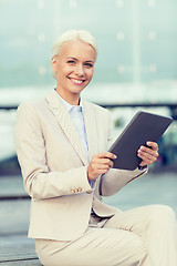 Image showing smiling businesswoman with tablet pc outdoors