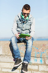 Image showing happy young man with tablet pc and headphones
