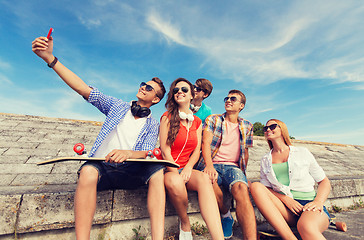 Image showing group of smiling friends with smartphone outdoors