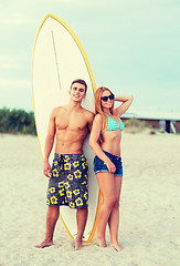 Image showing smiling couple in sunglasses with surfs on beach