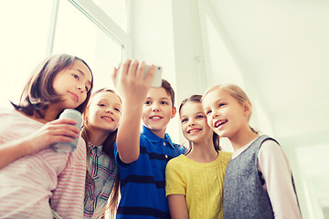 Image showing group of school kids with smartphone and soda cans