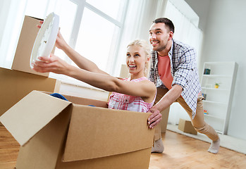 Image showing couple with cardboard boxes having fun at new home