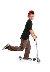 Image showing Child riding a scooter