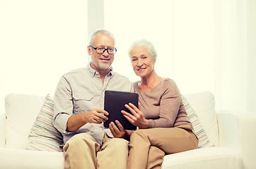 Image showing happy senior couple with tablet pc at home