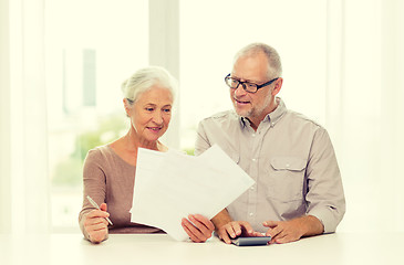 Image showing senior couple with papers and calculator at home