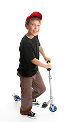 Image showing Boy standing beside a scooter