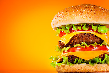 Image showing Tasty and appetizing hamburger on a yellow