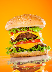 Image showing Tasty and appetizing hamburger on a yellow