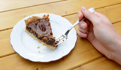 Image showing Woman holding a bite of pecan pie on her fork