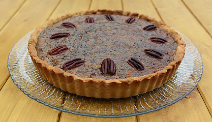 Image showing Freshly baked pecan pie on a glass plate