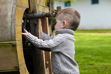 Image showing 2 years old curious Baby boy managing with old agricultural Mach