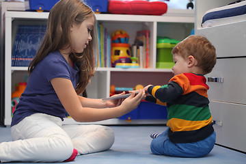 Image showing girl and her little brother arguing with a digital tablet comput