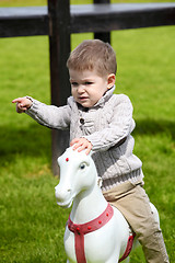 Image showing 2 years old Baby boy playing with horse