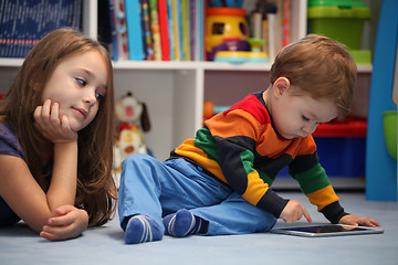 Image showing Disappointing girl with her little brother using a digital table