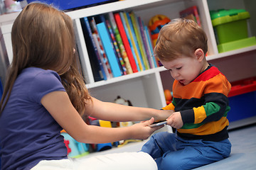 Image showing girl and her little brother crying and arguing with a digital ta