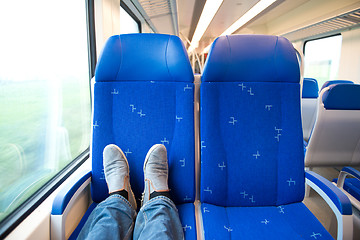 Image showing Traveling alone in a trein, feet on the seats