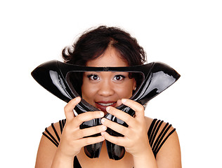 Image showing Beautiful woman holding high heels on face.