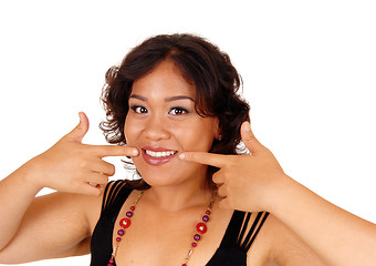 Image showing Smiling woman pointing at he teeth.