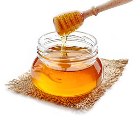 Image showing honey pouring into jar