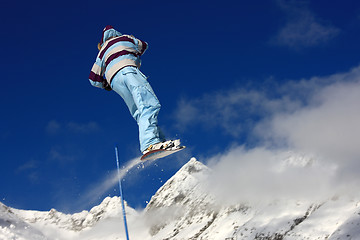 Image showing Snowboarder jumping high in the air