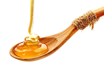 Image showing honey pouring into wooden spoon