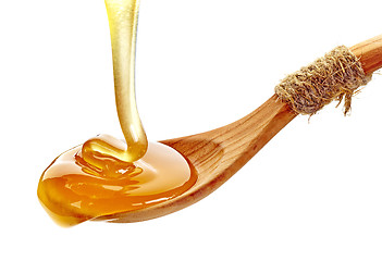 Image showing honey pouring into wooden spoon