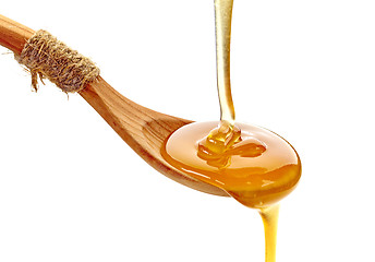 Image showing honey pouring into wooden spoon