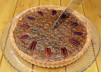 Image showing Starting to slice a pecan pie