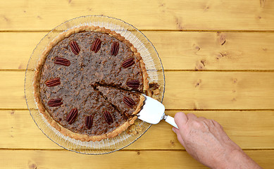 Image showing Woman serves a slice of pecan pie