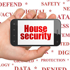 Image showing Privacy concept: Hand Holding Smartphone with House Security on display