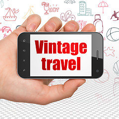 Image showing Tourism concept: Hand Holding Smartphone with Vintage Travel on display