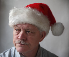 Image showing annoyed senior with a Santa hat