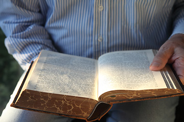 Image showing man reading old German Bible in sunlight