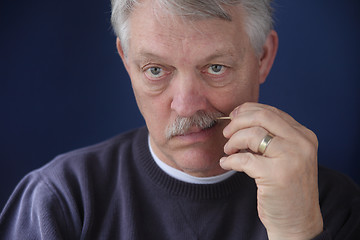 Image showing senior man using toothpick  