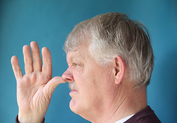 Image showing Older man thumbs his nose.