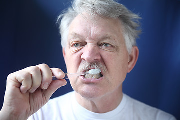 Image showing Mature man brushes teeth. 