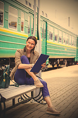 Image showing smiling woman is planning railway retro-travel